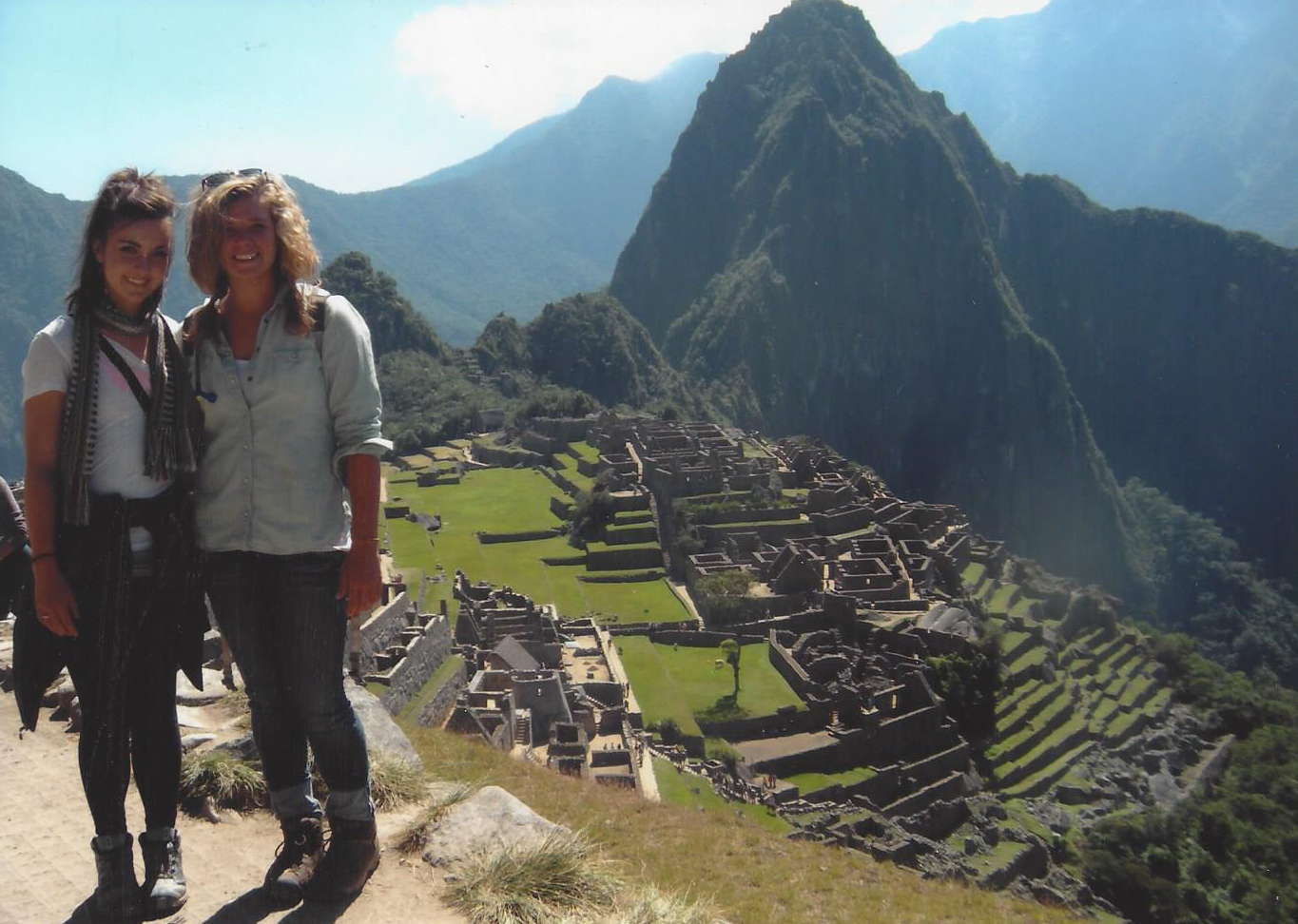 Two women standing above Machu Picchu