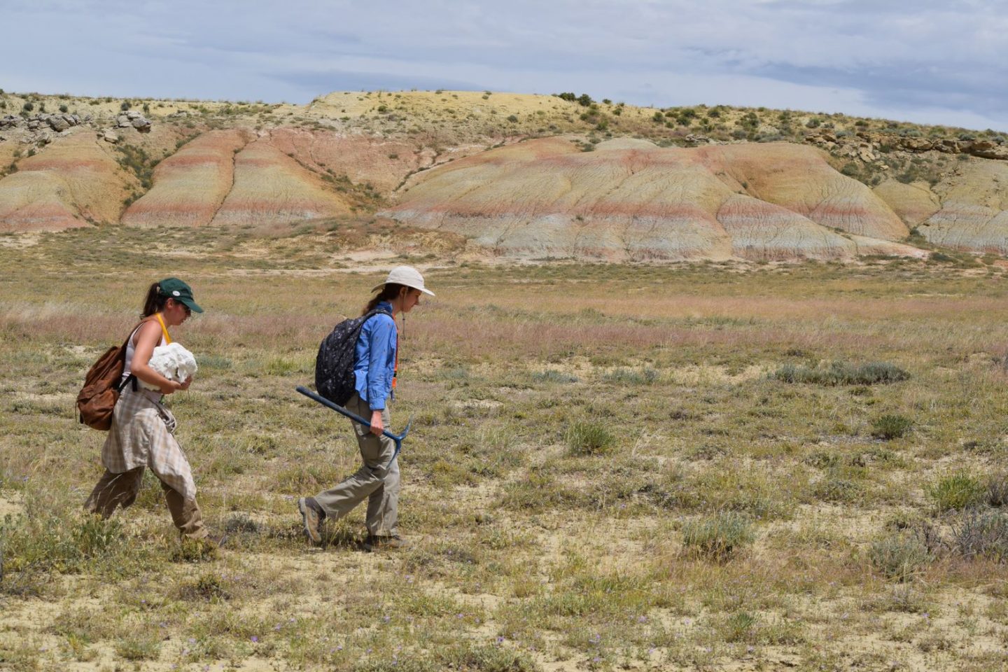 two students walking in Wyoming badlands during field school