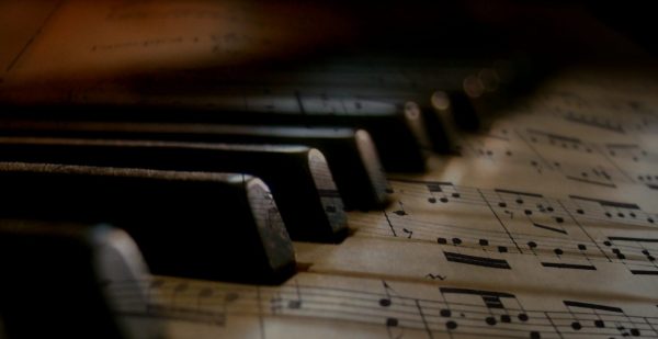 Black piano keys over sheet music for Music in the Museum Concert Series
