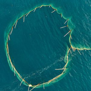Aerial view of large fishing net in ocean.