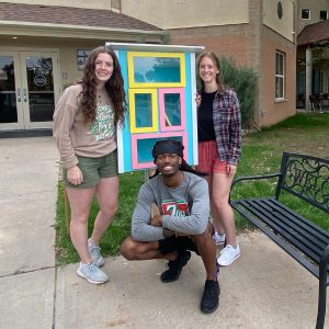 IAD Students working on the Little Library outside of the Catholic Charities building
