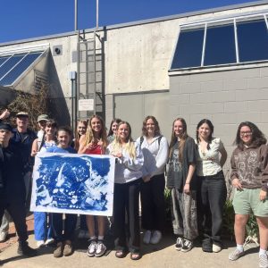 Class of students in Thresholds & Encounters // Meeting the Universe Halfway display their collectively created cyanotype print