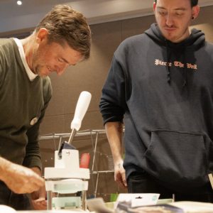 Faculty member and student work together to make buttons at the English Studies Possibilities Fair