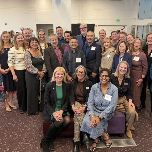 Large group photo of faculty and staff gathered for a celebration event at CSU, with attendees wearing name tags and posing together in a conference room.
