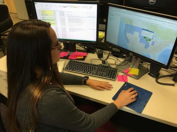 Rose Gorrell sitting in front of two computer screens