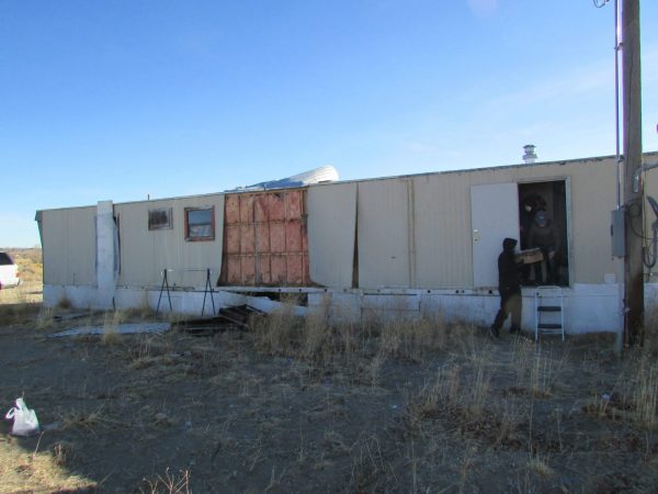 People removing materials from a damaged trailer