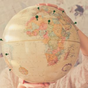 Globe with thumbtacks marking locations