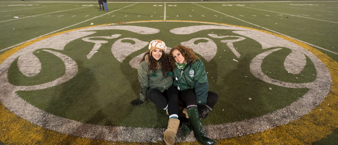 Jennifer Clary and her daughter sit in the middle of the field at Hughes Stadium
