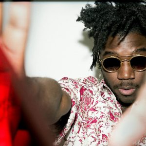 Tim Horton promotional photo, headshot Artist has hands outstretched toward camera