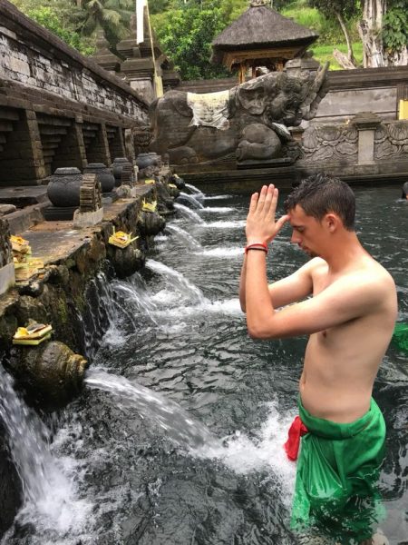 Spencer Sheaman in Bali performing a purification ritual at Trita Empul Temple