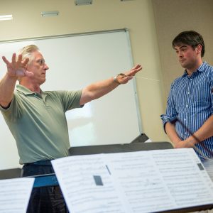 Wes Kenney pictured holding an advanced conducting class