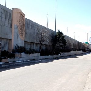A roadway next to a concrete wall that separates Interstate 70 with the Globeville neighborhood in Denver.