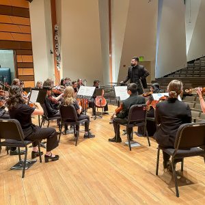 Paul Haarala works with strings students at CSU