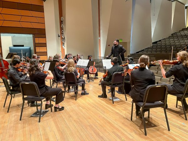 Paul Haarala works with strings students at CSU