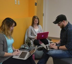 English seniors Hannah Kirby, Abigail Lutz and Andrew Eggleston sit in Willard O. Eddy Hall, before a class. (Photo credit: Megan Fischer.)