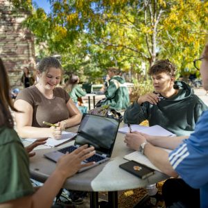Students work collaboratively at a table outside Eddy Hall