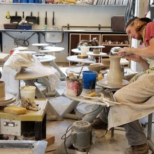 Two students making clay pots