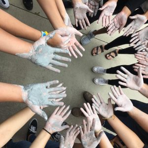 Pottery students show their clay colored hands