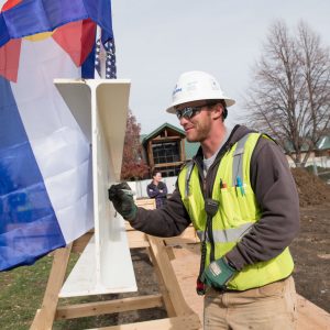 color photo of a construction worker signing a beam for the Translational Medicine Institute