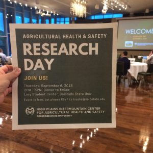 a hand holding a flyer that says Research Day
