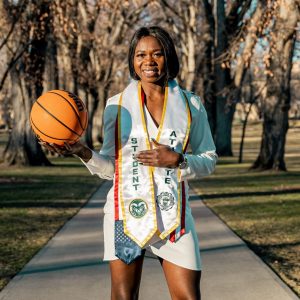 Upe Atosu posing on the oval in her regalia, basketball in hand