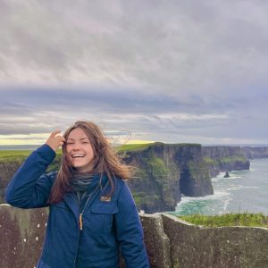 Ellie Martinez standing on a seaside cliff in Ireland