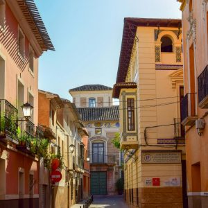 Brown buildings with balconies on a street in Mula, Spain