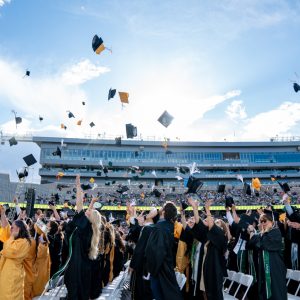The class of 2025 throws their caps at the conclusion of University-wide Commencement at Canvas Stadium.