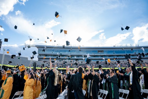 The class of 2025 throws their caps at the conclusion of University-wide Commencement at Canvas Stadium.