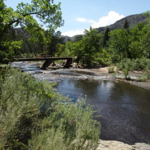 Photo of the Poudre River with a USDA employee speaking with a family on a bridge