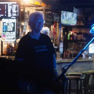 Yvette Rippee, the "Pop Punk Grandma," smiling at a singer during a punk rock concert
