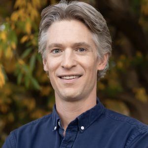 Headshot of Nick Marx wearing blue button-up shirt