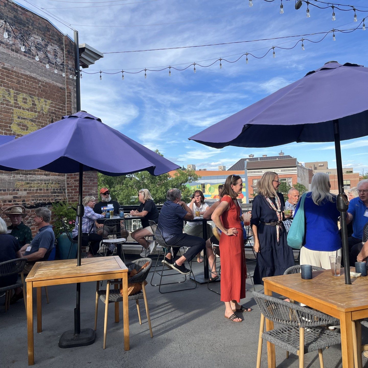 Great Conversations members gather at a rooftop restaurant for summer soiree