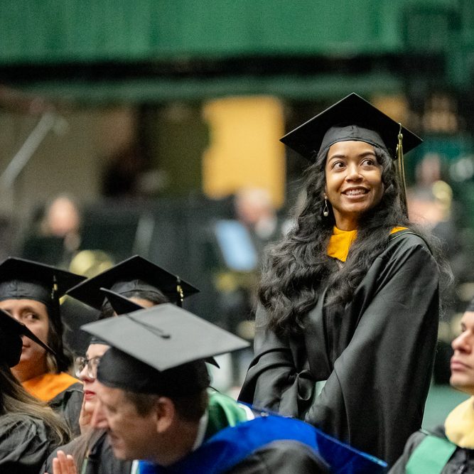 Student smiling during Graduate School commencement ceremony